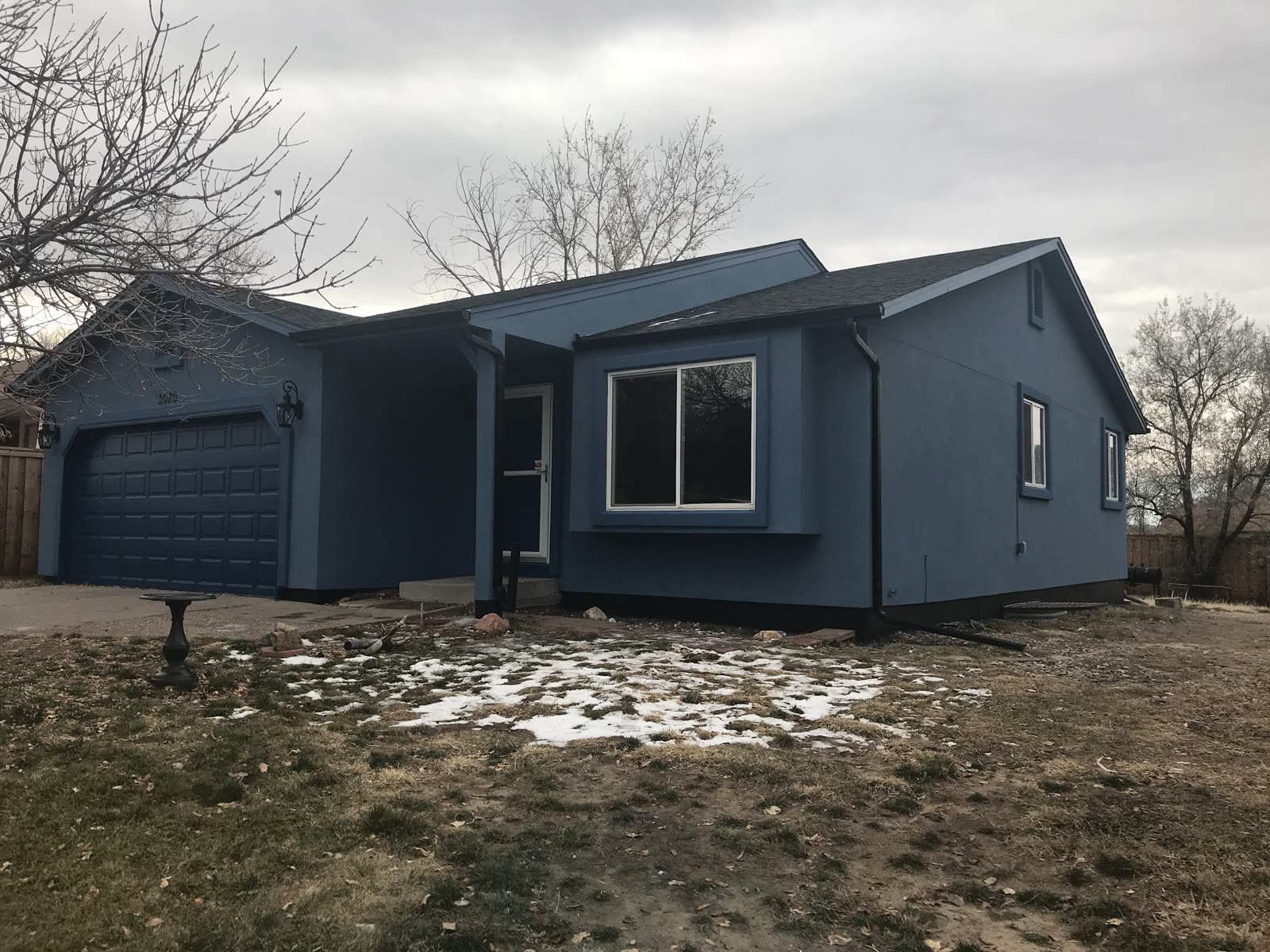 Slate-blue ranch-style home painted by Confident Coatings